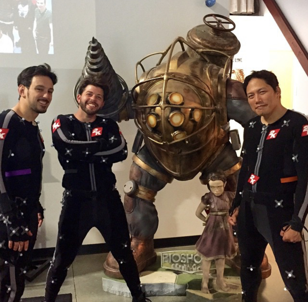 Sari Sabella in motion capture suit at 2K Games with BioShock Big Daddy statue